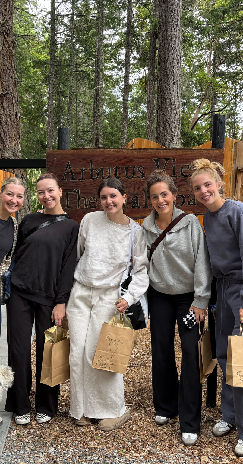 Guests at the hand-carved Arbutus View sign with personalized gift bags from the owners